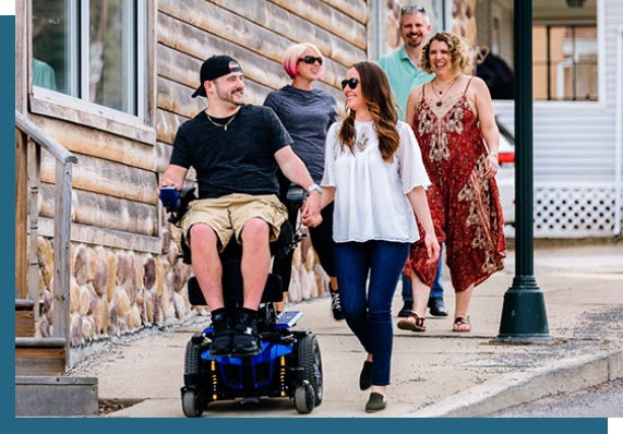 man walking with woman while seated in wheelchair