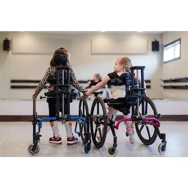 two female children embracing in a dance class in their Prime Engineering KidWalk Pediatric Gait Trainers